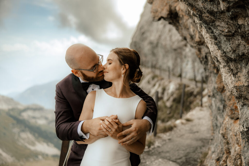 After-wedding shooting auf dem Pilatus in Luzern. Brautpaar küsst sich eng umschlungen in der Berglandschaft