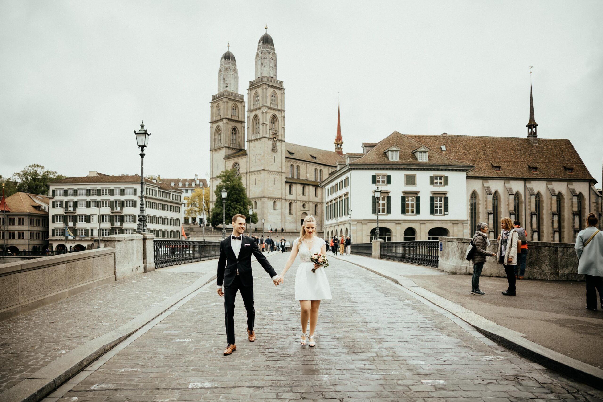 Brautpaar läuft ueber Muensterbruecke in zuerich-hochzeitsfotograf